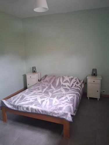 a bed in a bedroom with two nightstands and two tables at maison reposante in Payrignac