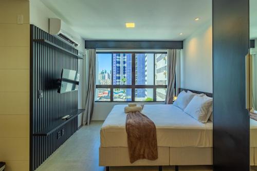 a bedroom with a bed with a large window at Allure Residence by Carpediem in Recife