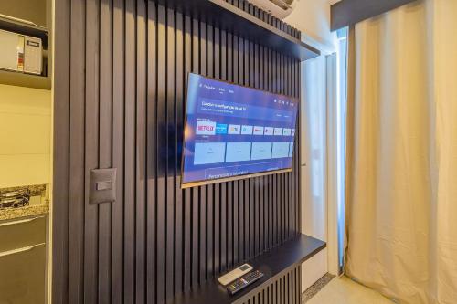 a flat screen tv on a wall in a room at Allure Residence by Carpediem in Recife