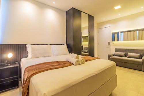 a bedroom with a large bed and a couch at Allure Residence by Carpediem in Recife