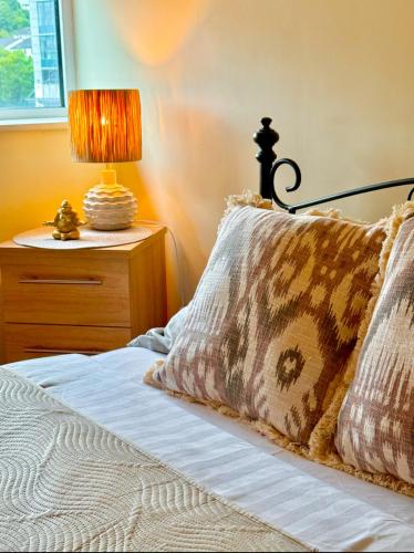 a bed with a pillow and a lamp on a night stand at Heron Gate Comfort, Park and Pillow in Cork