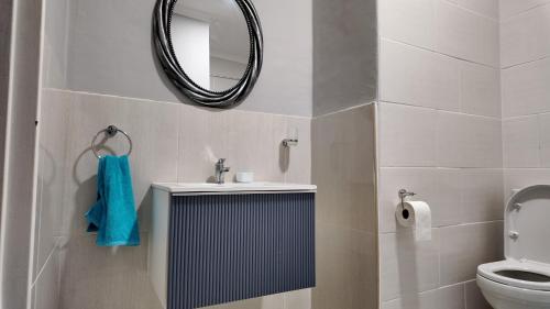 a bathroom with a sink and a mirror and a toilet at Bungalow Guest House Phase 4 in Gaborone