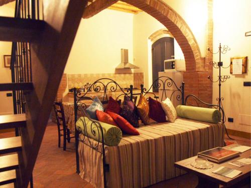 a bed with colorful pillows on it in a room at La Fornace di San Galgano in Chiusdino