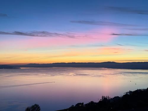 a sunset over a large body of water at Villa Lavaux in Grandvaux