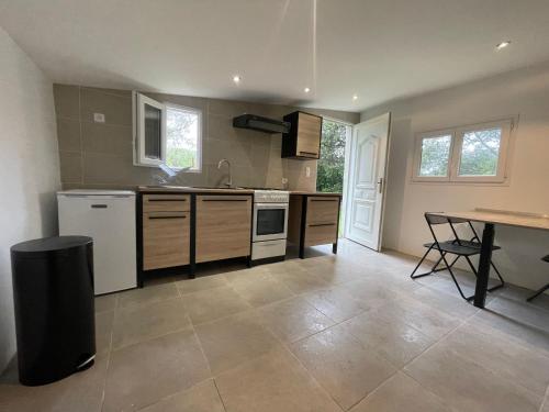 une grande cuisine avec une table et un comptoir dans l'établissement 2 mini villas indépendantes campagne saint flo, à Saint-Florent