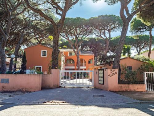 une maison orange avec un portail et des arbres dans l'établissement Apartment Les Maldives-2 by Interhome, à Hyères