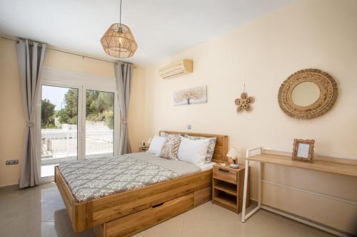 a bedroom with a bed and a large window at Palmtrees Apartments in Afantou