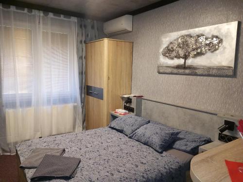 a bedroom with a bed and a tree on the wall at Penzion Vulture Ostrava in Ostrava