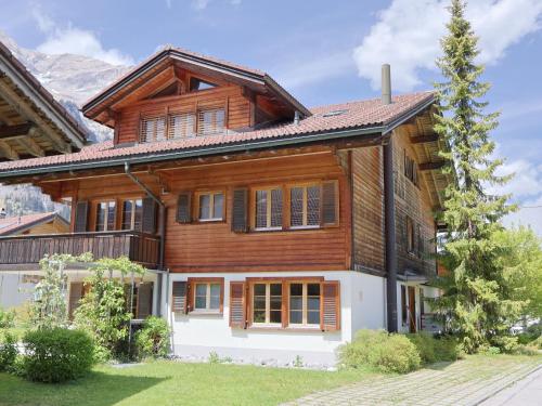 a wooden house with a gambrel roof at Apartment Haus Europa by Interhome in Kandersteg