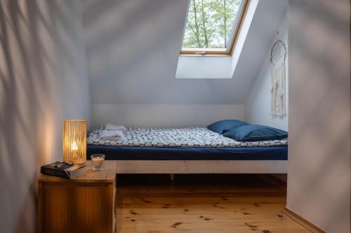 un lit dans une petite pièce avec une fenêtre dans l'établissement Słowicze Gniazdo Kopalino, à Kopalino