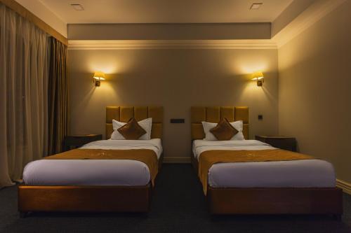 a hotel room with two beds in a room at Ambassador Hotel in Bishkek