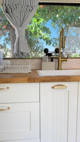 a kitchen counter with a sink and a window at אלומה- בוטיק בטבע in Sheʼar Yashuv