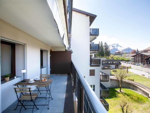 un balcone con tavolo e sedie su un edificio di Apartment Gamat 27 by Interhome a Villars-sur-Ollon