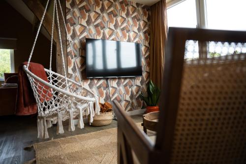 a living room with a tv hanging on a wall at TweeZeven in Guelle