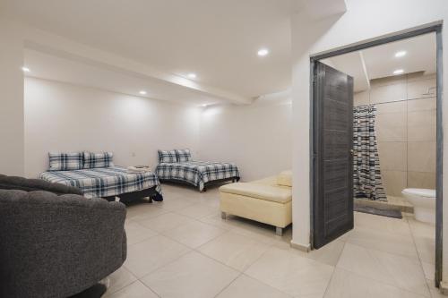ein Badezimmer mit zwei Betten und einer Couch und einer Toilette in der Unterkunft Casa Ferlioni in Temixco