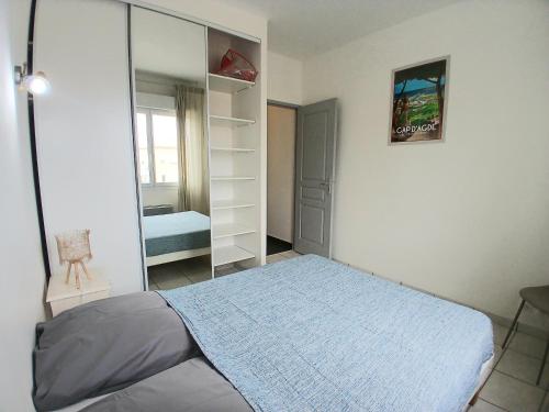 une chambre avec un lit et un miroir dans l'établissement Maison Basalte, au Cap d'Agde