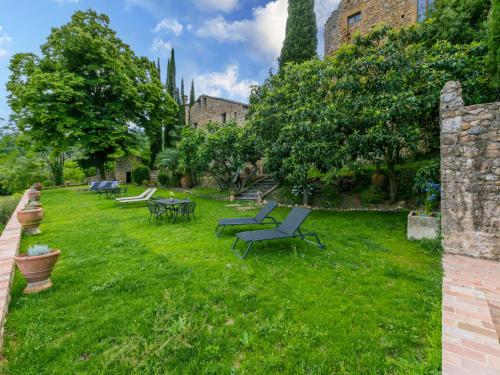 a lawn with chairs and tables in a yard at Apartment La Torre-5 by Interhome in Stigliano
