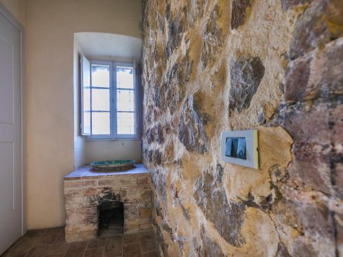 a room with a stone wall with a tv on it at Apartment La Torre-5 by Interhome in Stigliano