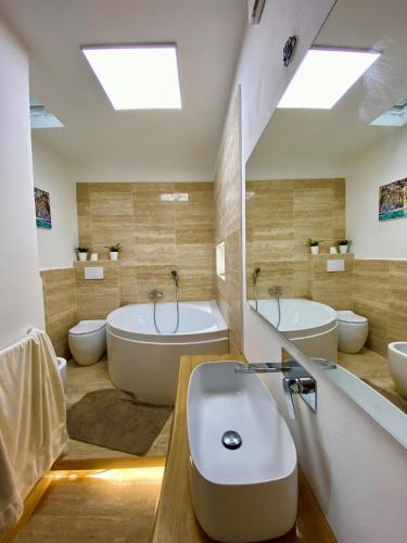 a bathroom with two sinks and a tub and two toilets at Vistalaguna Orbetello in Orbetello