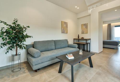 a living room with a blue couch and a table at Marea Luxury Suites in Koríthion
