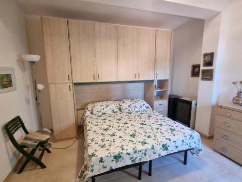 a bedroom with a bed and a chair and cabinets at Casa Alessia Taormina in Taormina