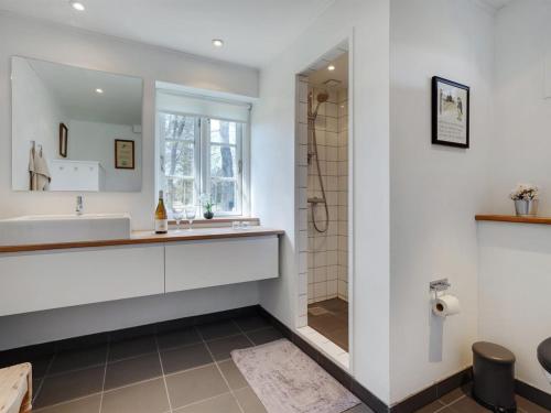 a bathroom with a tub and a sink and a shower at Holiday Home Githe - from the sea by Interhome in Hals