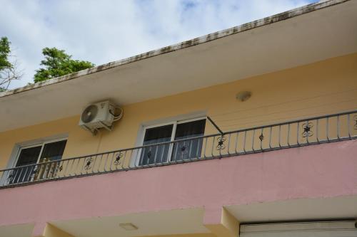 a balcony on the side of a building with a fan at Guesthouse Odobashi in Çorovodë