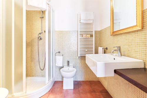a bathroom with a sink and a toilet and a shower at La Chicca Palace Hotel in Milazzo