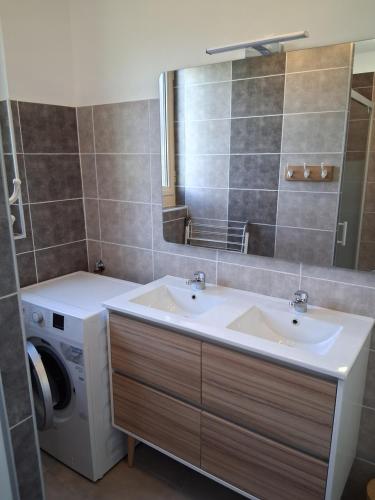 une salle de bain avec un lavabo et une machine à laver dans l'établissement Maison à la campagne idéale famille et amis, à Montayral
