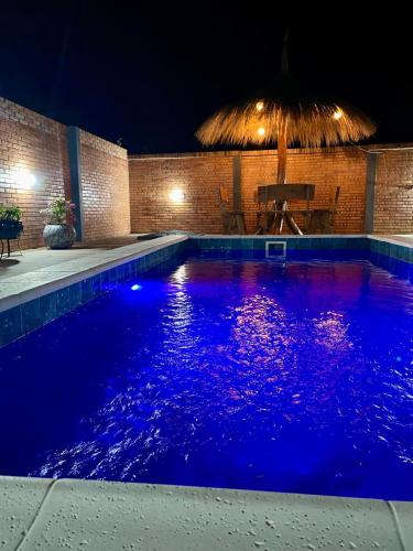 a swimming pool at night with blue illumination at Cabaña Premium Ñakurutu de La Mala Junta in Atyrá