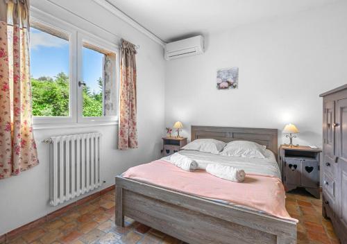 ein Schlafzimmer mit einem großen Bett und einem Fenster in der Unterkunft Villa provençale calme avec piscine chauffée 6 ch in Le Rouret