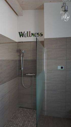 a bathroom with a shower with a wellness sign on the wall at Apartment Inge in Rheinhausen