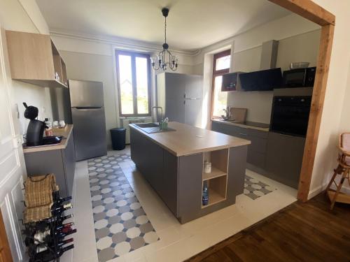 une cuisine avec un îlot au milieu dans l'établissement Maison de famille en Haute Corrèze, à Maussac