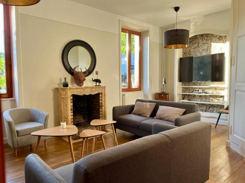 un salon avec un canapé et une cheminée dans l'établissement Maison de famille en Haute Corrèze, à Maussac