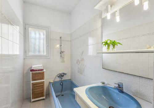 ein Badezimmer mit einer blauen Badewanne und einem Waschbecken in der Unterkunft Villa provençale calme avec piscine chauffée 6 ch in Le Rouret