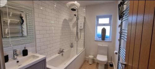 een badkamer met een bad, een wastafel en een toilet bij The Hide Away in Cromer