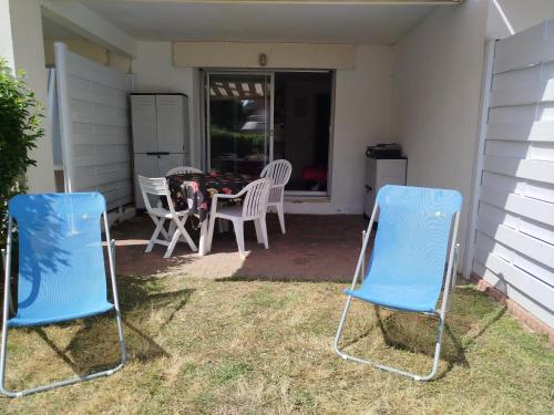 - deux chaises bleues et une table sur une terrasse dans l'établissement Studio carnac, à Carnac