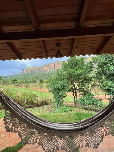 a hammock on a porch with a view of mountains at Pousada Jipe Canastra in Capitólio