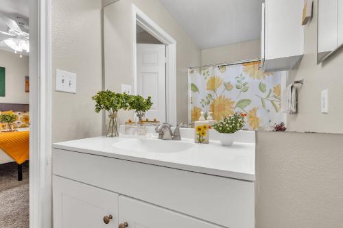 a white bathroom with a sink and a mirror at Casa Marigold ATX - Cozy Stay - Near DT & Airport in Austin