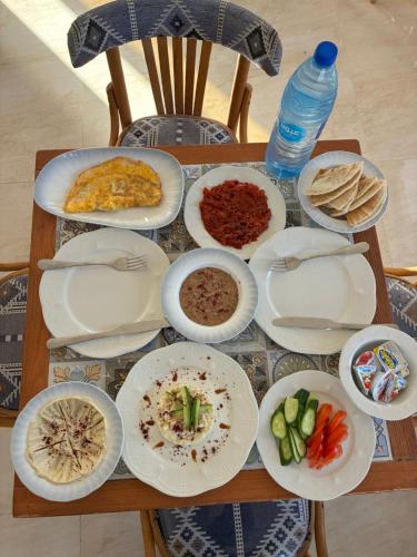 a table with plates of food and a bottle of water at Camel Dive Club By The Sea Inn in Jurf ad Darāwīsh