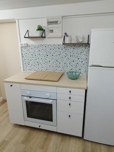 Il comprend une cuisine équipée d'appareils électroménagers blancs et d'un réfrigérateur blanc. dans l'établissement Disney grand F2 dans maison terrasse privée, à Bouleurs