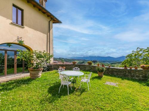 a patio with a table and chairs on the grass at Apartment I Puledri by Interhome in Pelago