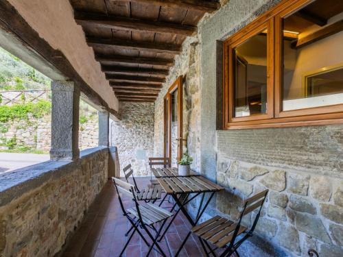 a patio with a table and chairs on a stone wall at Apartment I Puledri by Interhome in Pelago