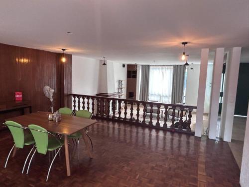 a dining room with a table and green chairs at Habitacion Berlin en The Green Door in Aguascalientes