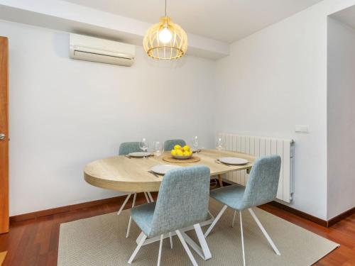 une salle à manger avec une table en bois et des chaises bleues dans l'établissement Apartment Costa Serena by Interhome, à Sant Antoni de Calonge