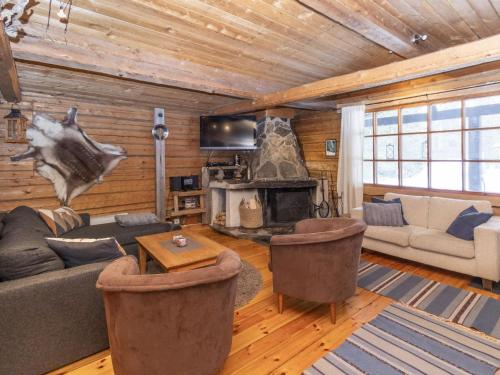 a living room with a couch and a fireplace at Holiday Home Savottakämppä by Interhome in Luosto