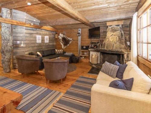 a living room with a couch and a fireplace at Holiday Home Savottakämppä by Interhome in Luosto