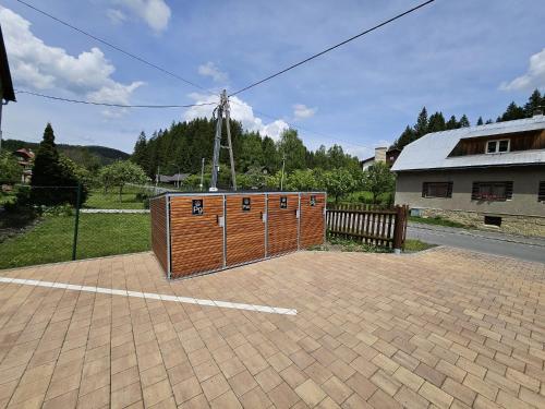 a large wooden building in a parking lot at Apartmány Jezerné in Velké Karlovice