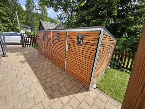 a large wooden shed with a number on it at Apartmány Jezerné in Velké Karlovice