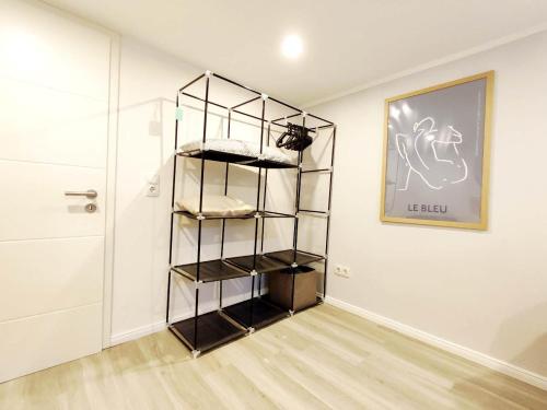 a room with a shelf with towels on it at Flair-Apartments 'SALZ & FLAIR' Kurstadt-Appartment, 450 m Bahnhof, für Urlaub oder Geschäftsreise, innenstadtnah, separater Eingang, 24 Std Check-in,WLAN, 55 Zoll-Fernseher, Streaming, Küche, Regendusche, Doppelbett, Schlafsofa in Bad Salzuflen